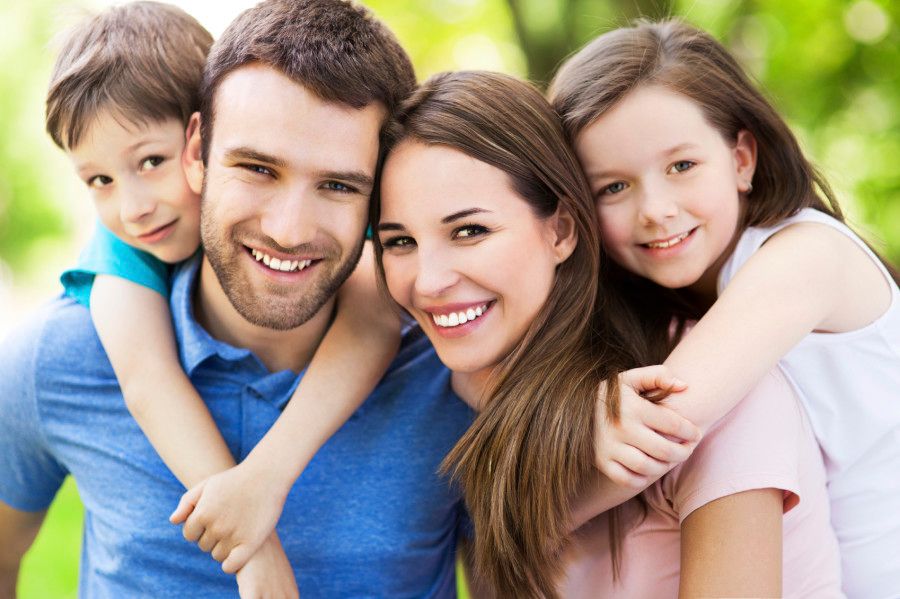 Smiling family, happy with our Exceptional Dental Services.